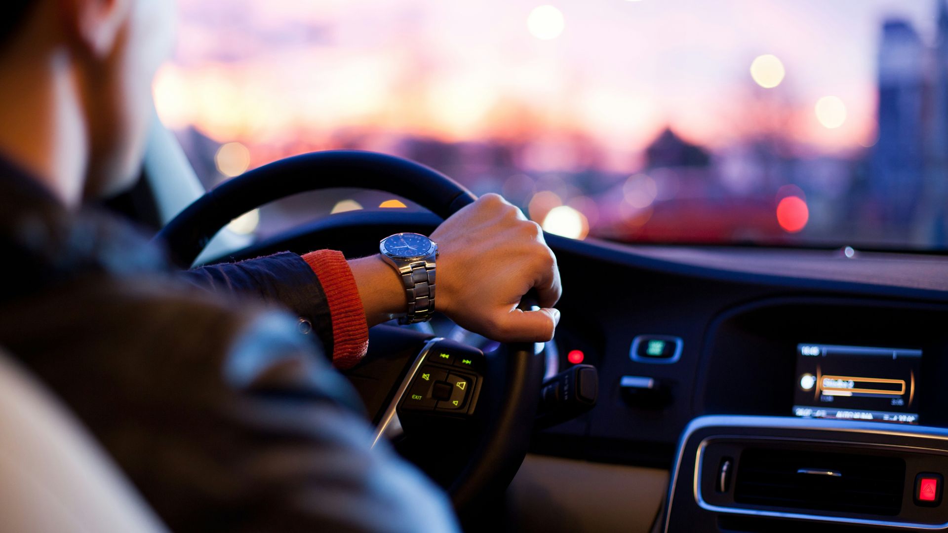man driving a car wearing wrist watch