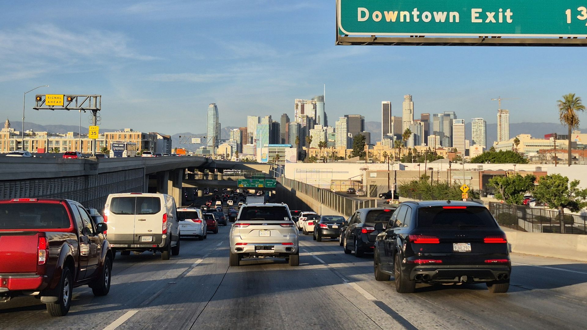A highway filled with lots of traffic next to tall buildings