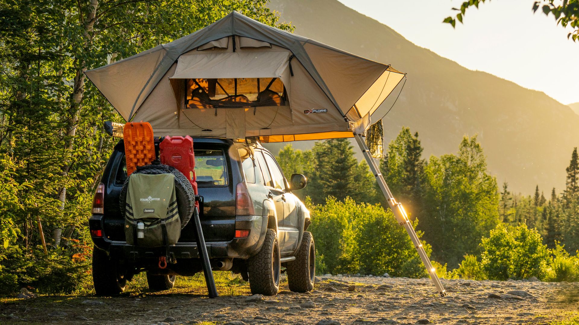 man in green jacket sitting on black and yellow camping chair near tent during daytime