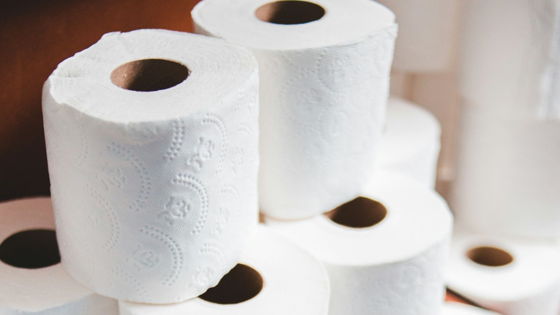 white toilet paper roll on brown wooden table