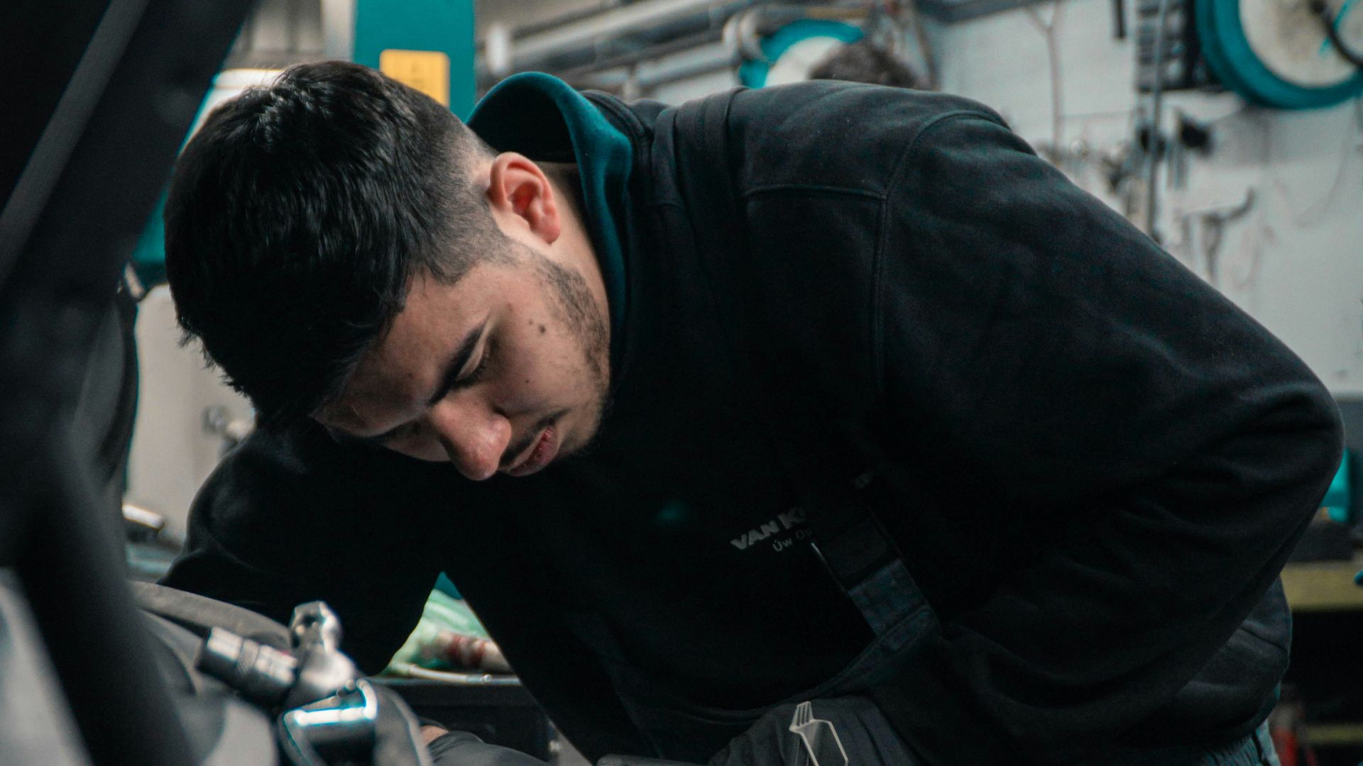 man in black jacket and blue denim jeans riding motorcycle