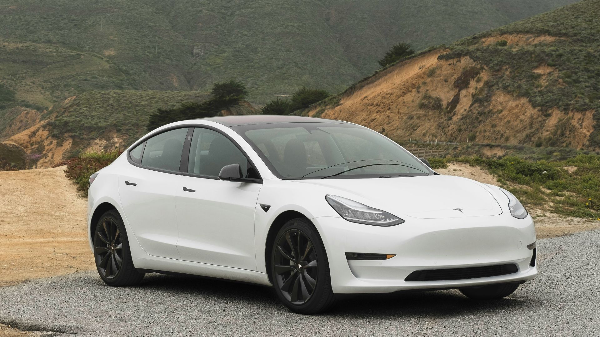 white sedan parked beside mountain during daytime