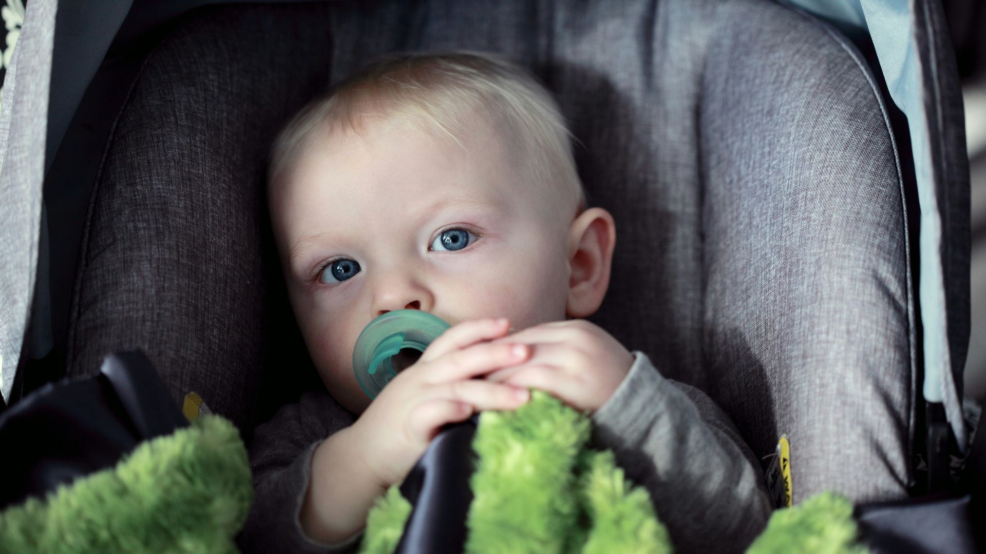 baby on gray stroller