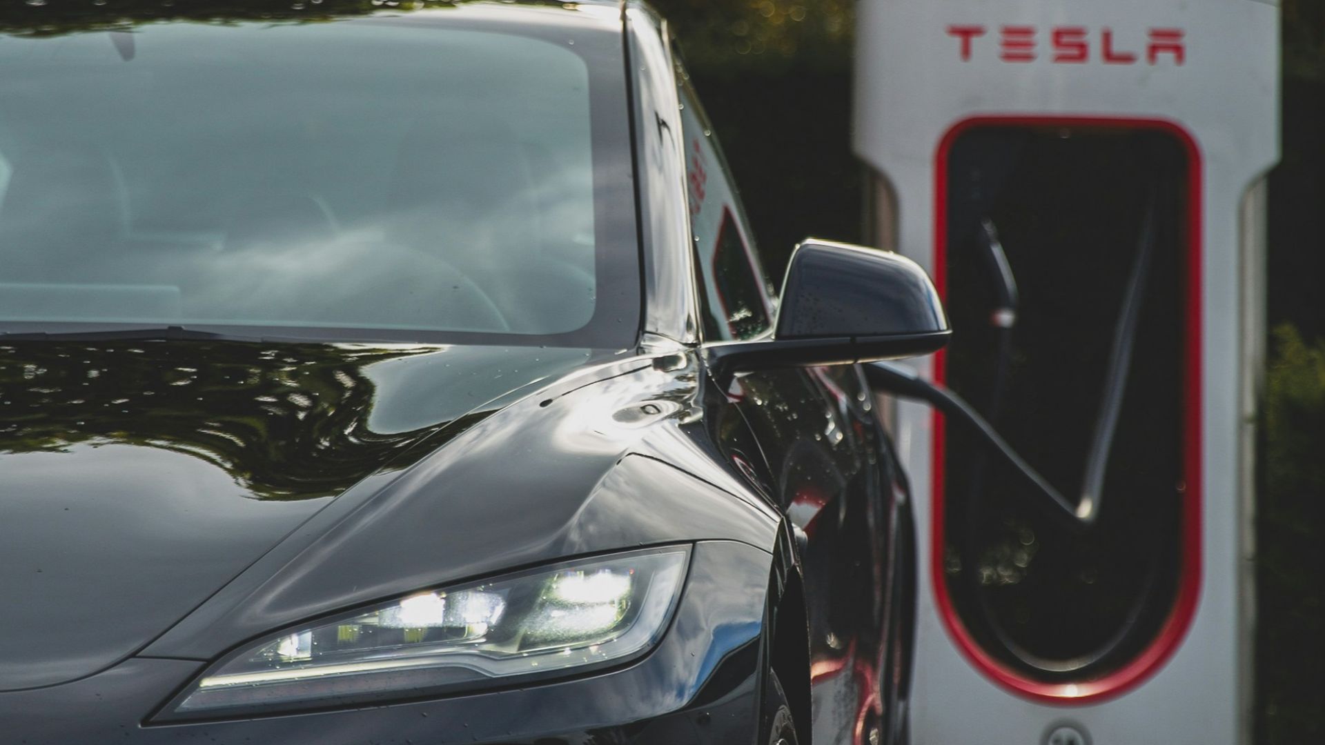 a tesla electric car plugged in to a charging station