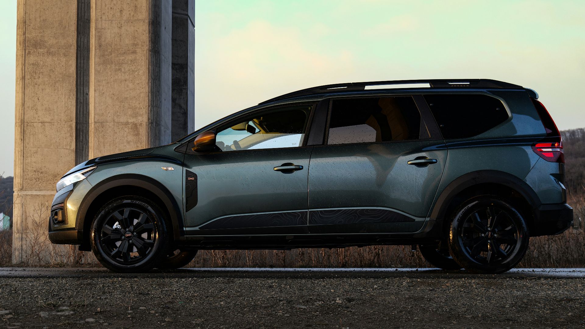 a grey car parked in front of a tall building