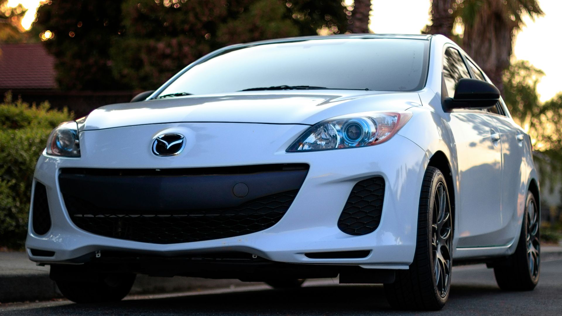 white Mazda sedan on road