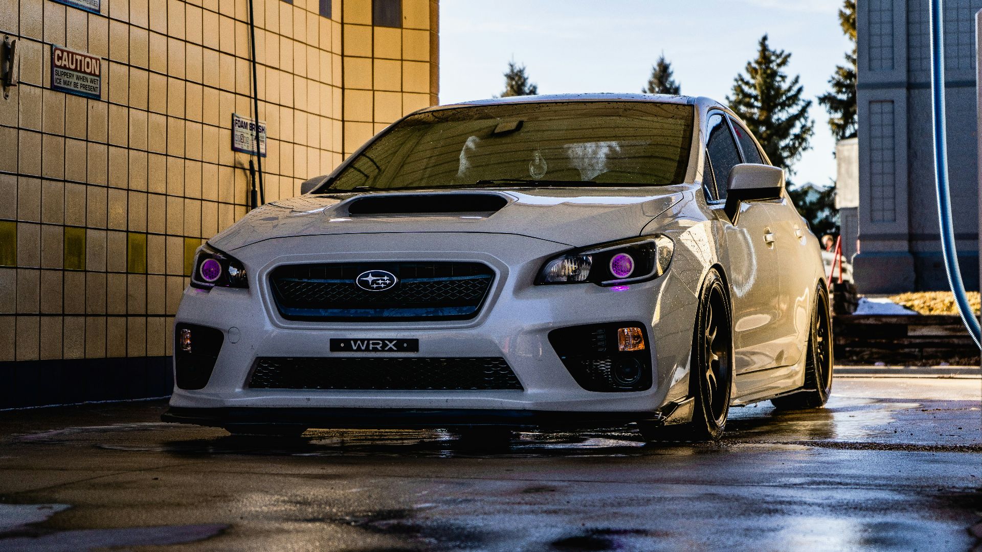 white honda car parked beside brown brick wall