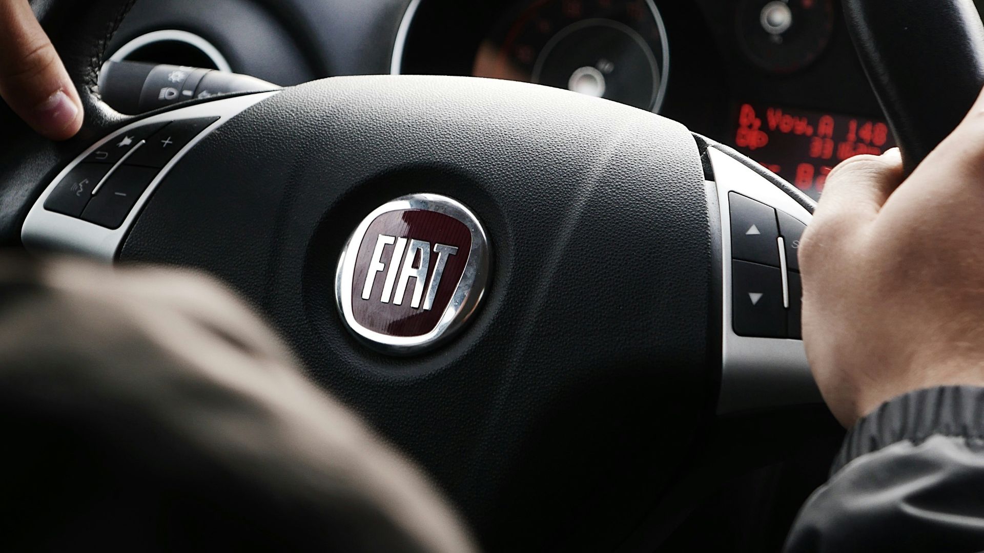 person riding FIAT car during daytime