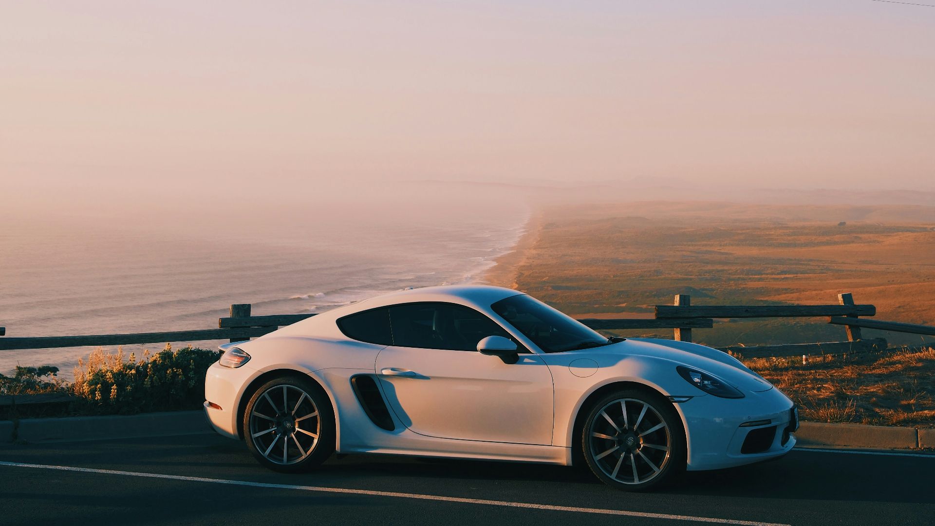A white sports car driving down a highway