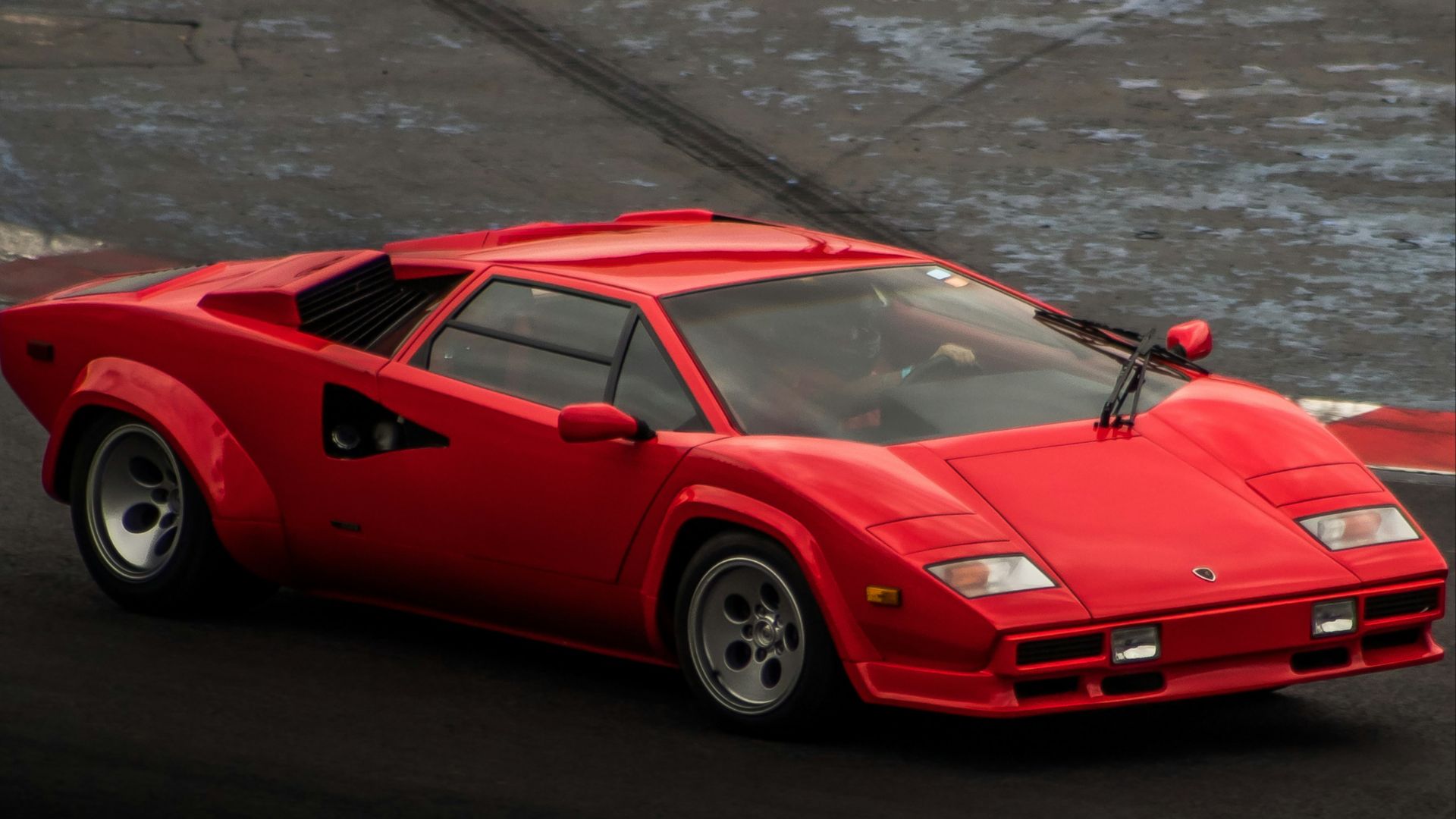 a red sports car driving down a race track