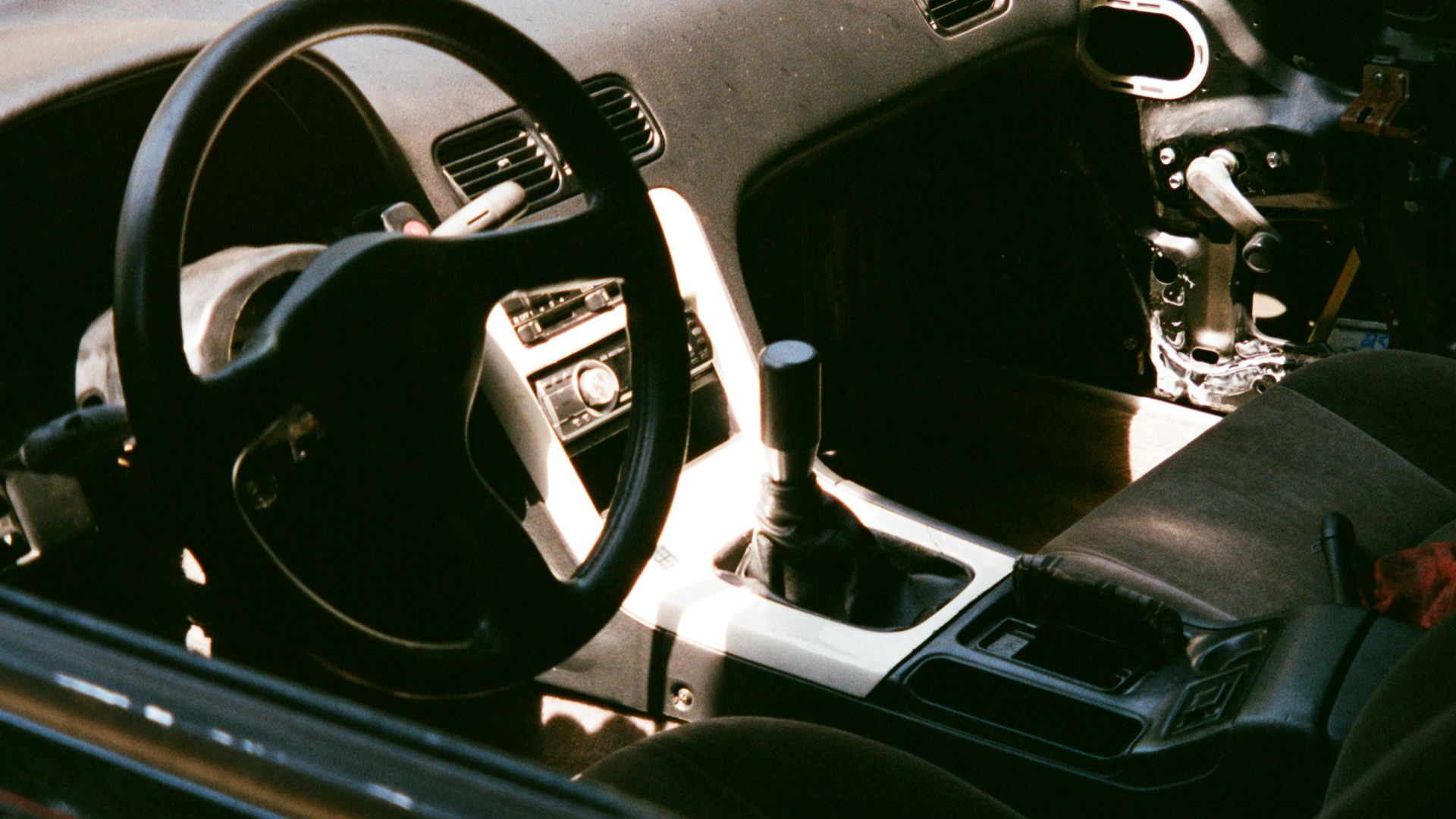 The interior of a car with a steering wheel and dashboard