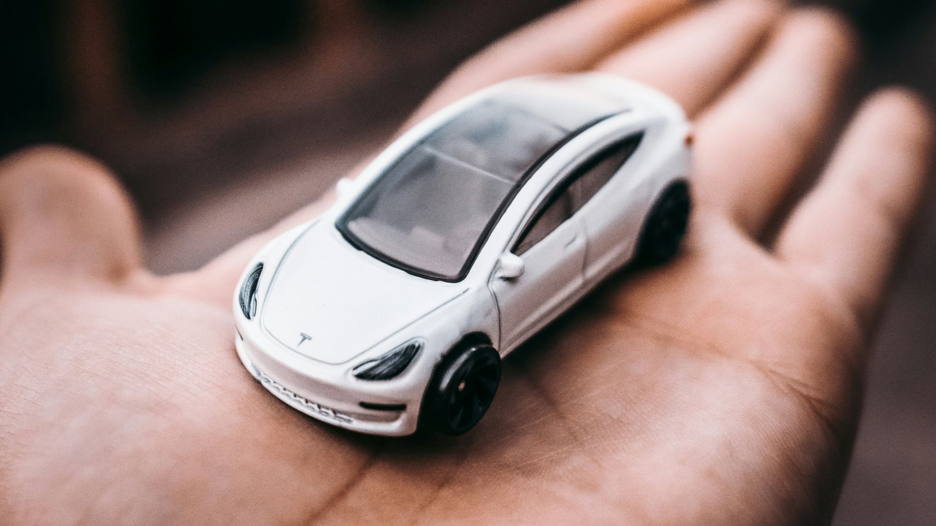 person holding white and black car scale model
