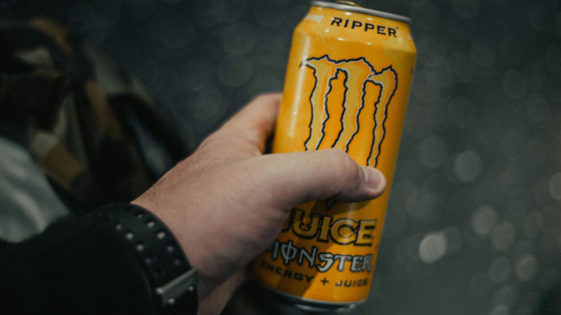 person holding yellow and black can