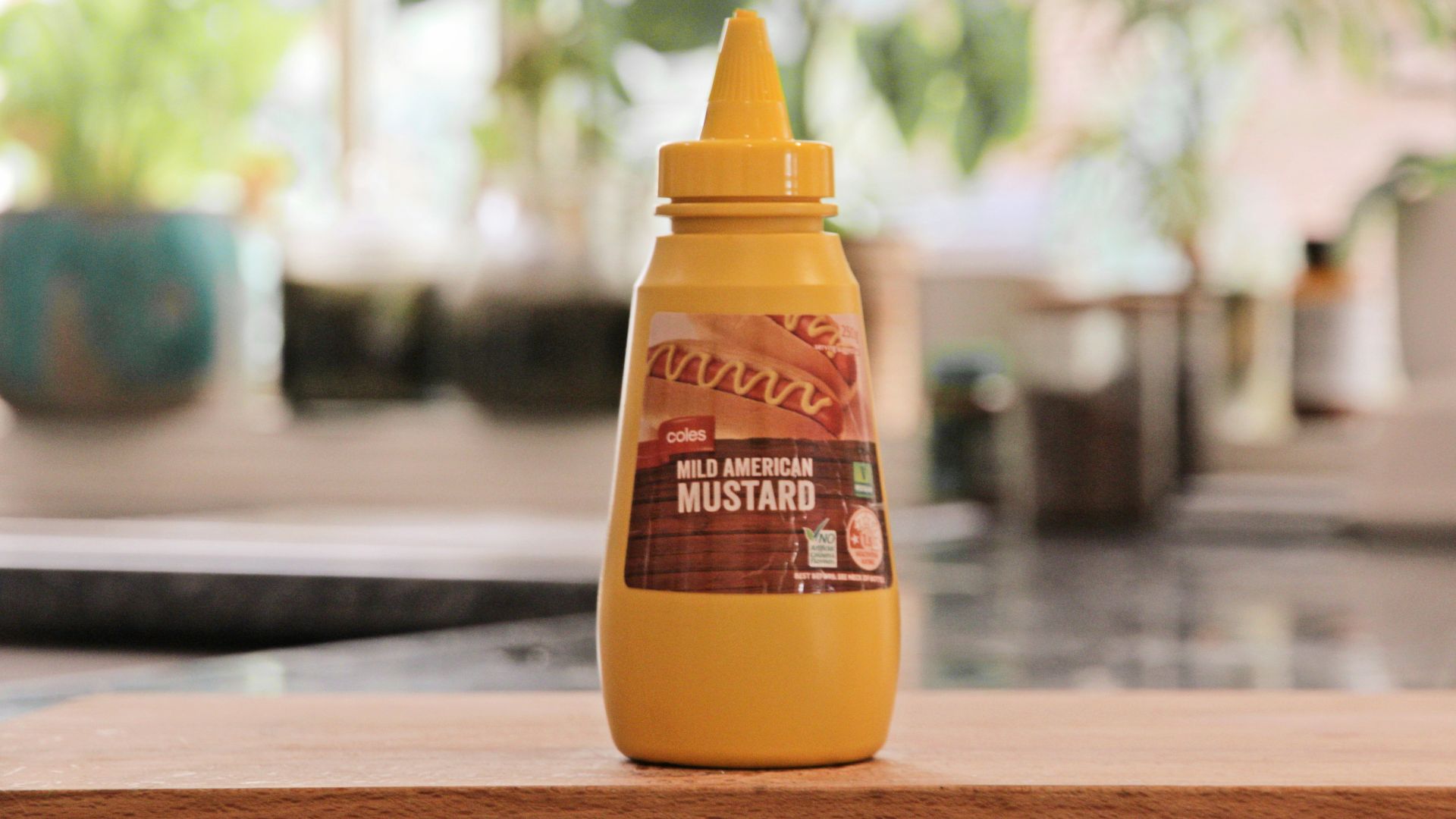 a bottle of mustard sitting on top of a wooden table