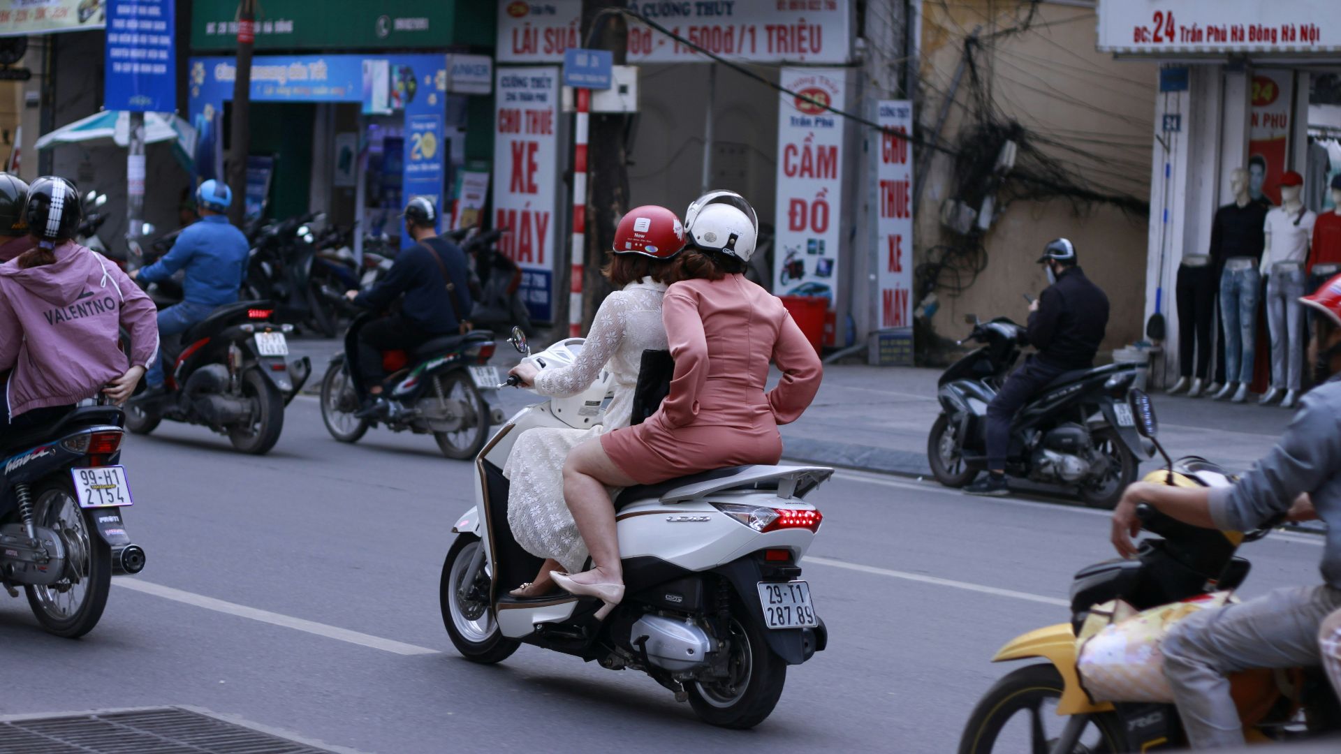 man in orange jacket riding motorcycle on road during daytime