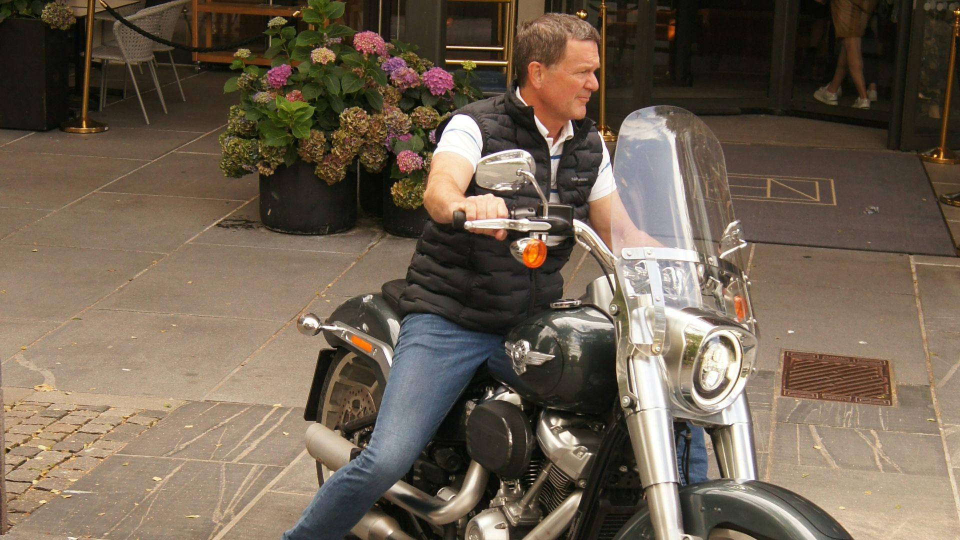 a man sitting on a motorcycle in front of a building