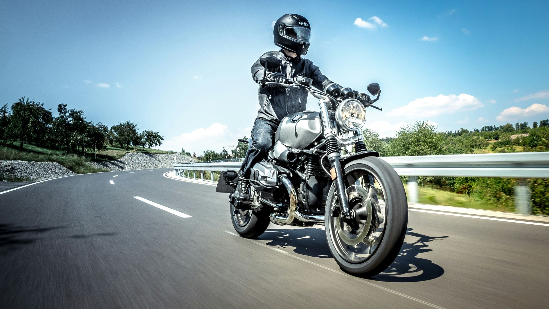man in black helmet riding on black motorcycle on road during daytime