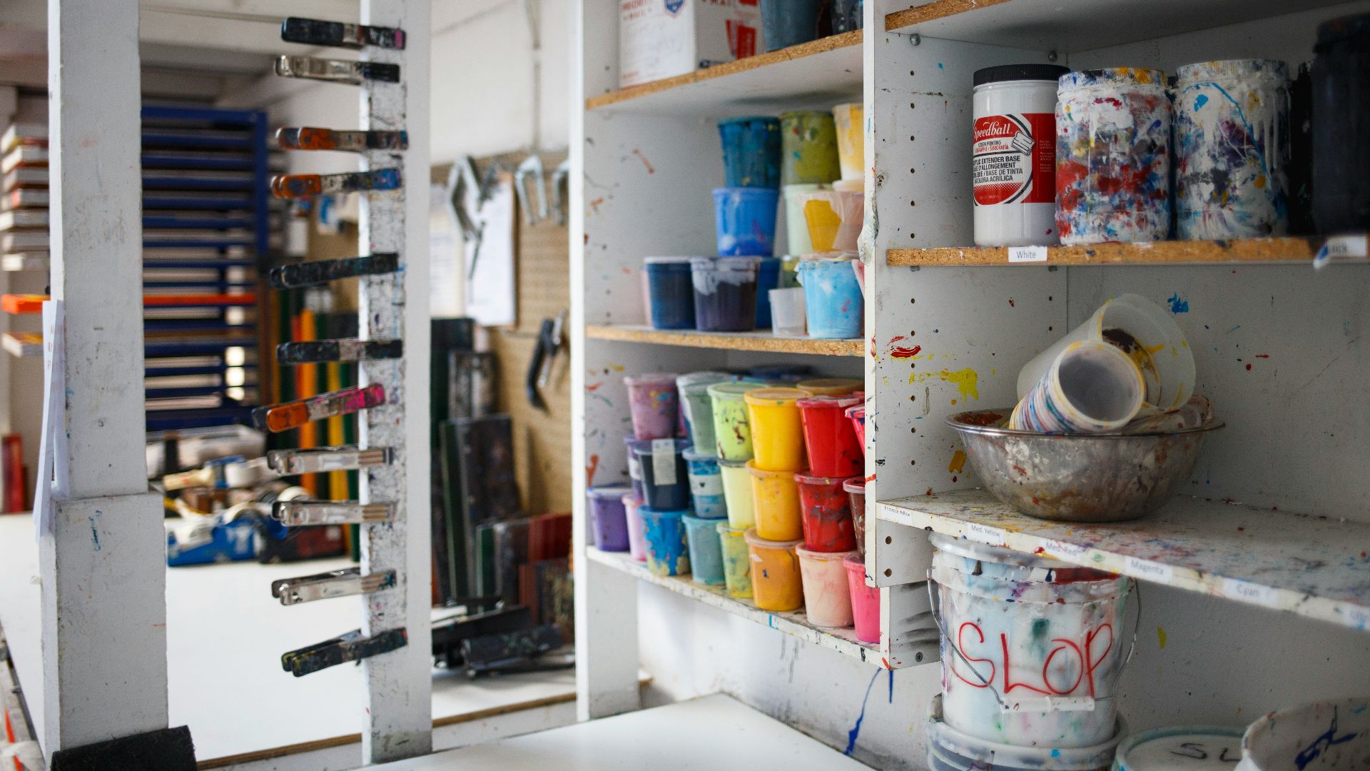 person taking photo of paint containers on display rack
