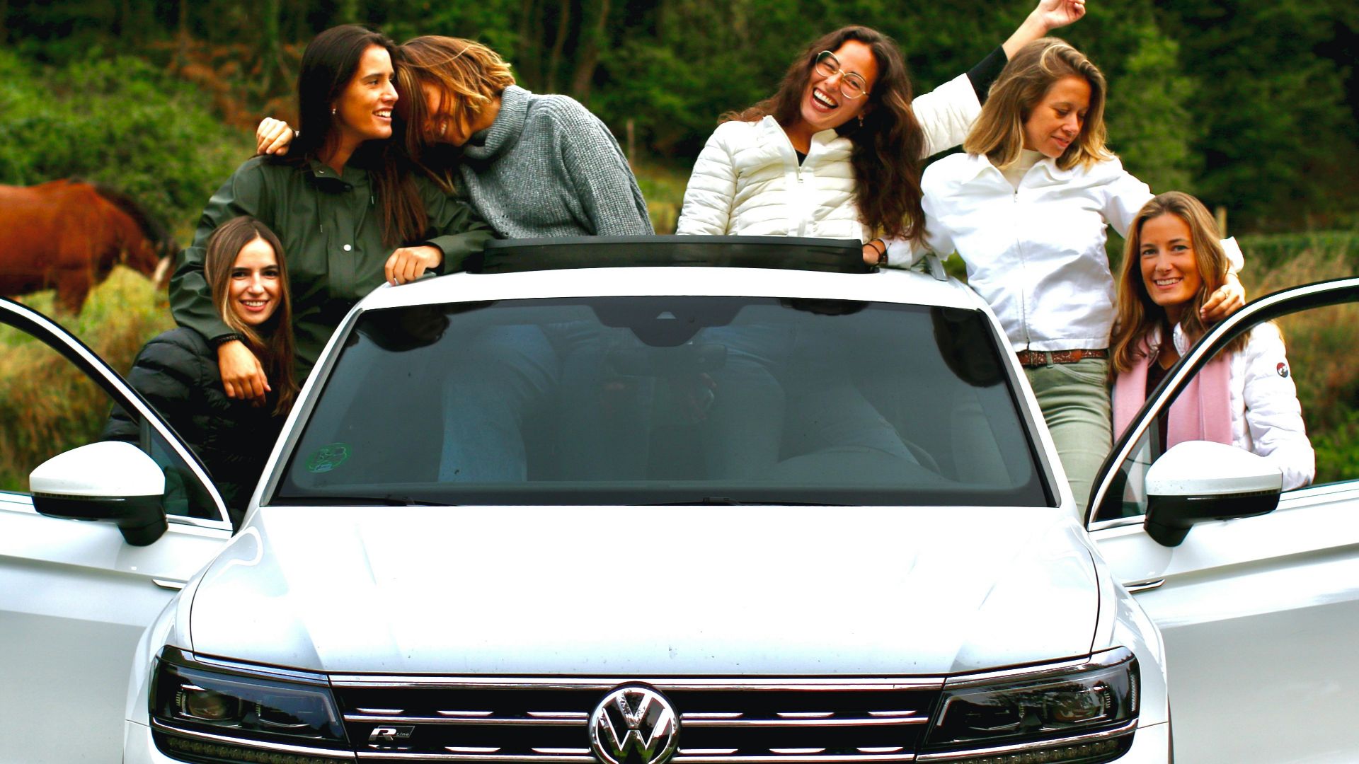 group of people standing beside white car during daytime