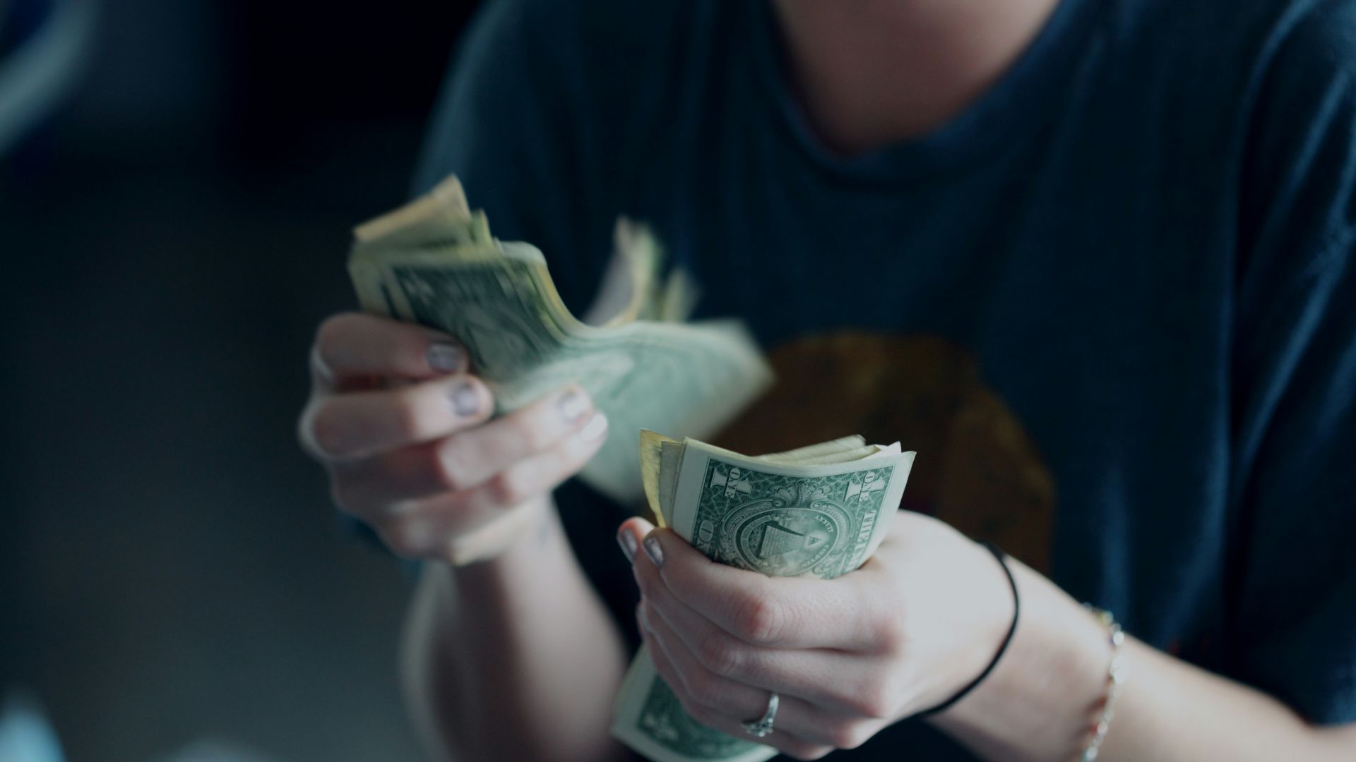 focus photography of person counting dollar banknotes