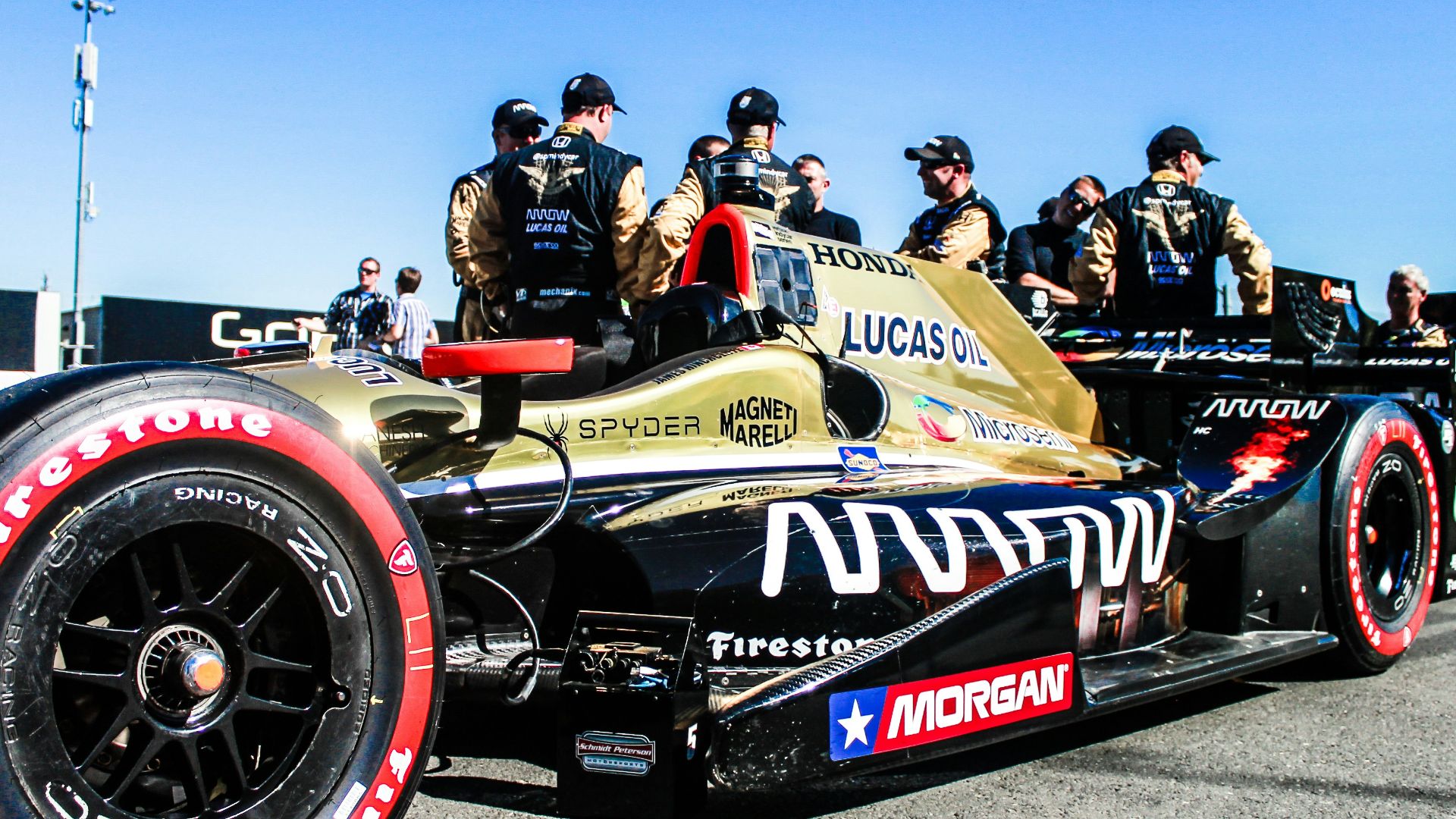 group of people standing near formula 1 car