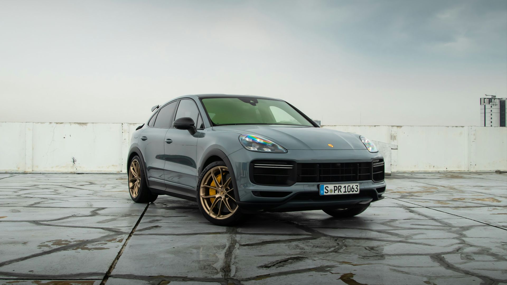a grey porsche cayen is parked in a parking lot