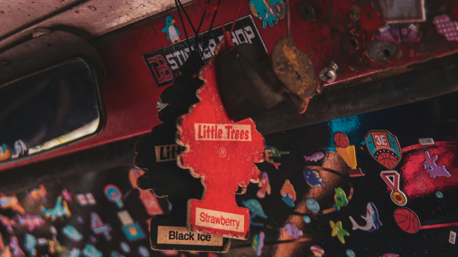 Car interior filled with stickers and air fresheners.