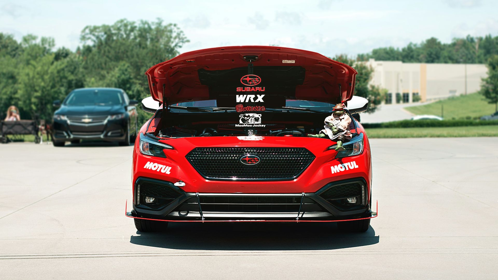 A red racecar has its hood open.