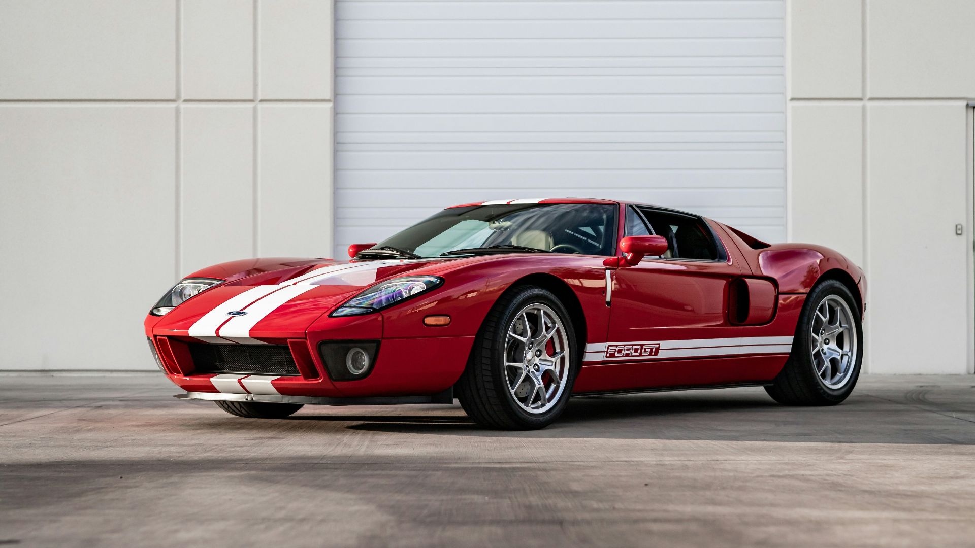 a red sports car parked in front of a garage