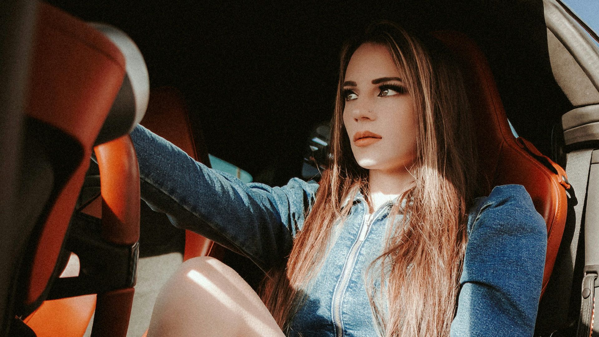 woman in blue denim jacket sitting on car seat