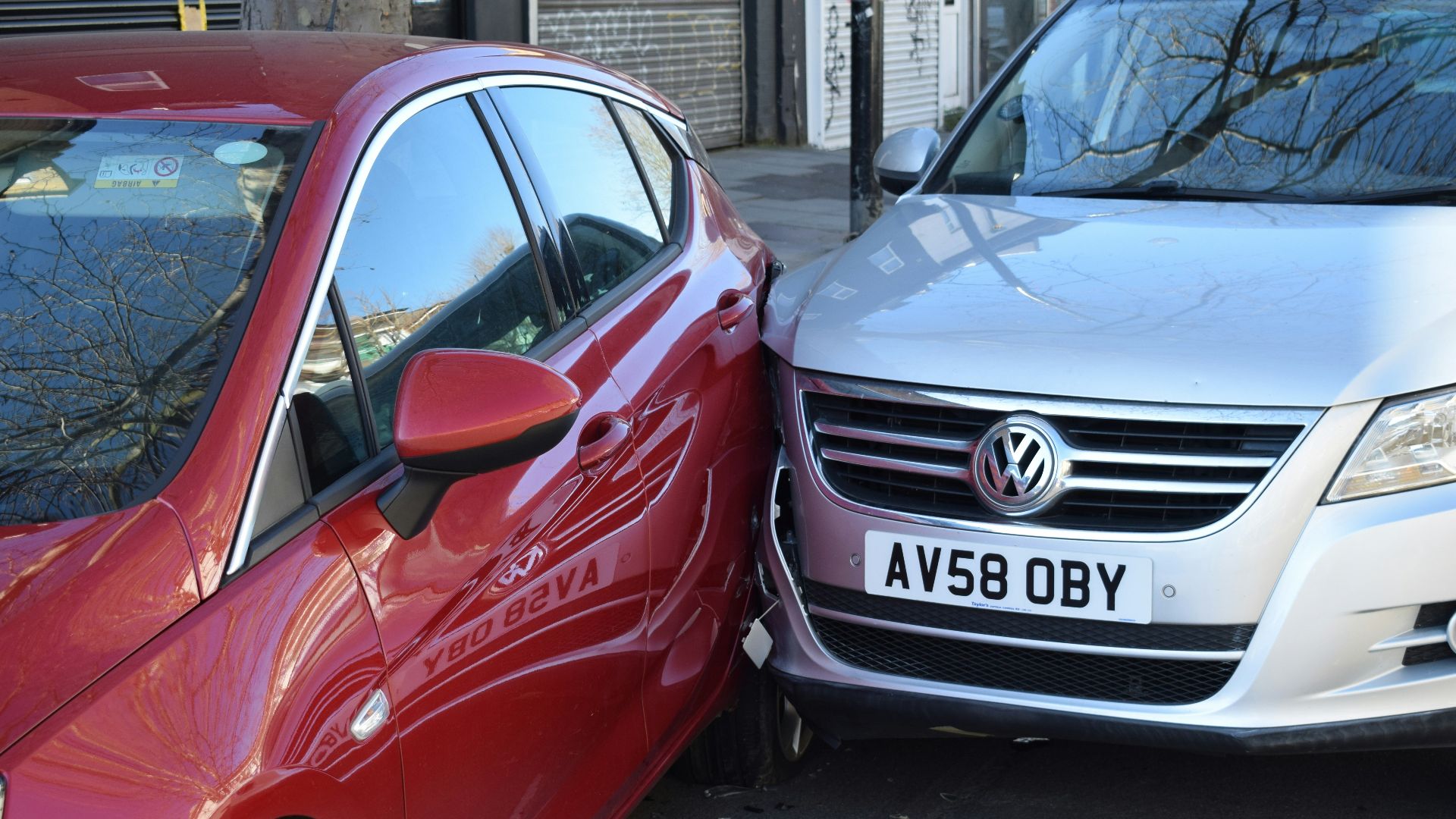 two cars parked next to each other in a parking lot