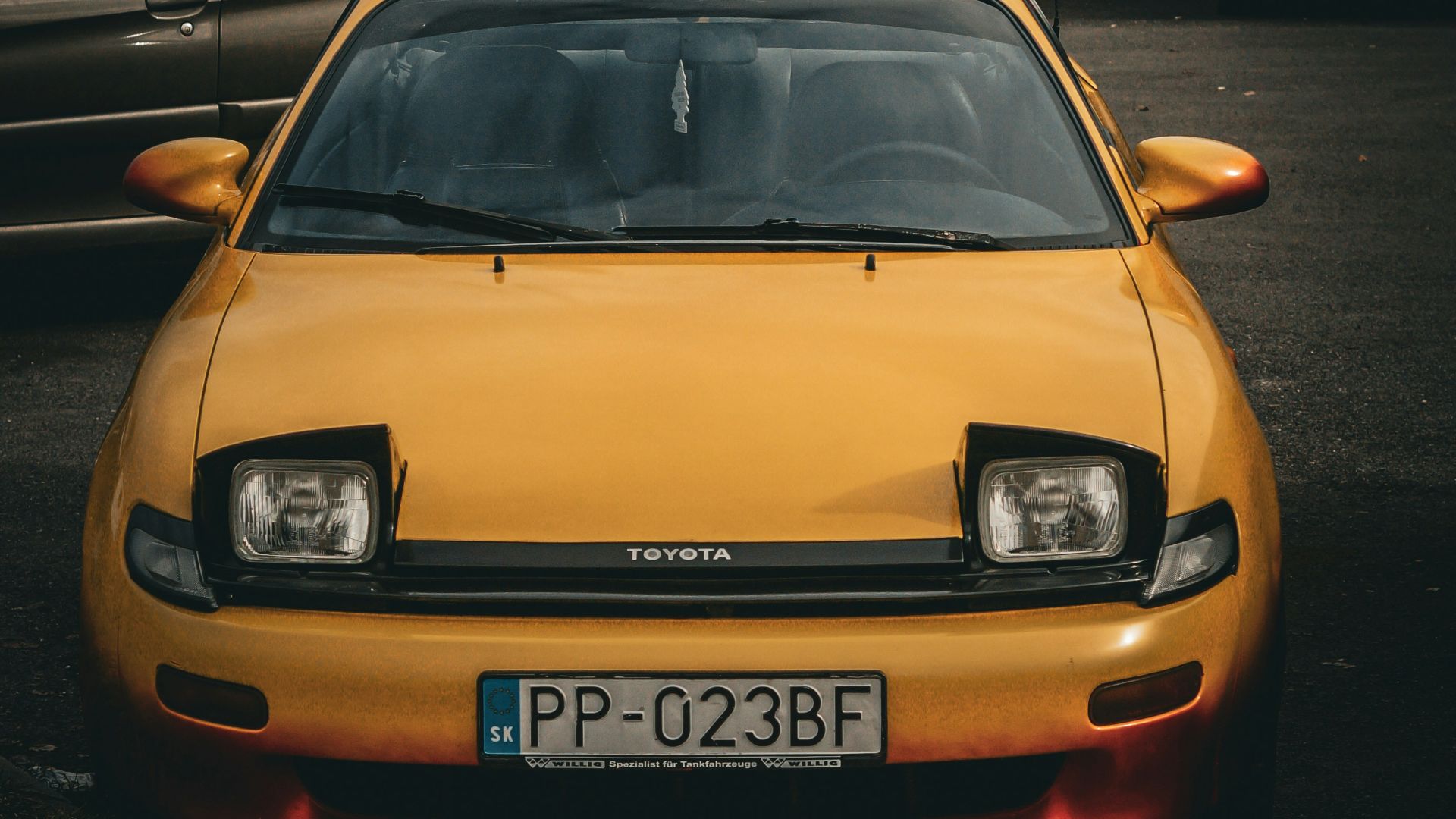 a yellow car parked in a parking lot