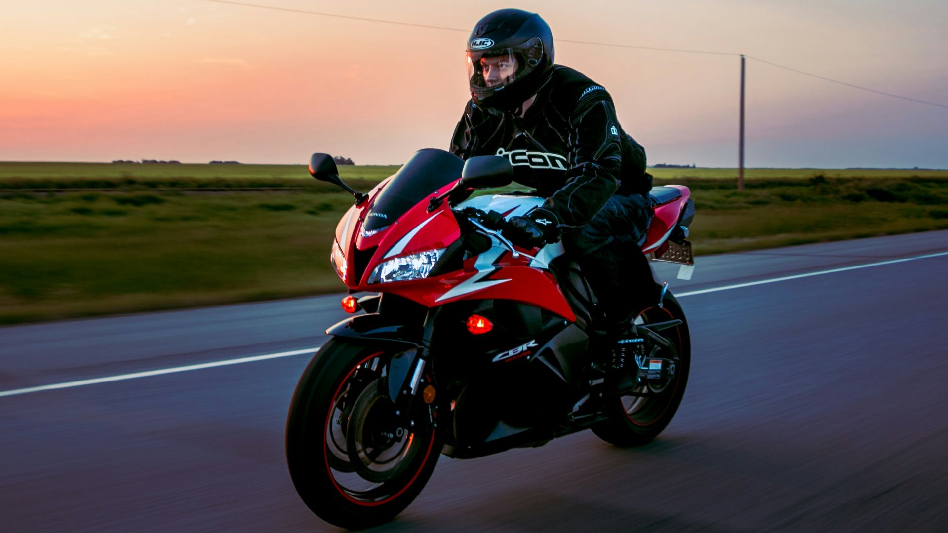 man riding sports motorcycle on road