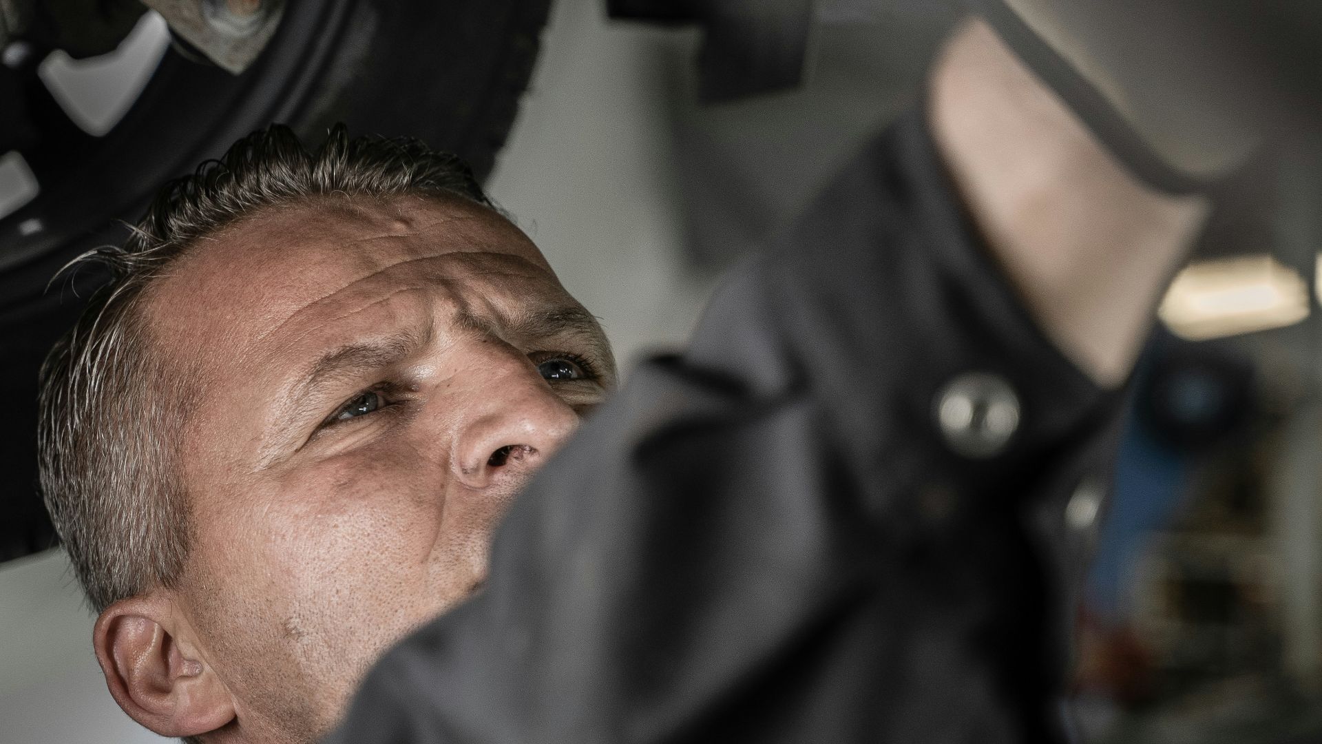 a man working on a car under a vehicle