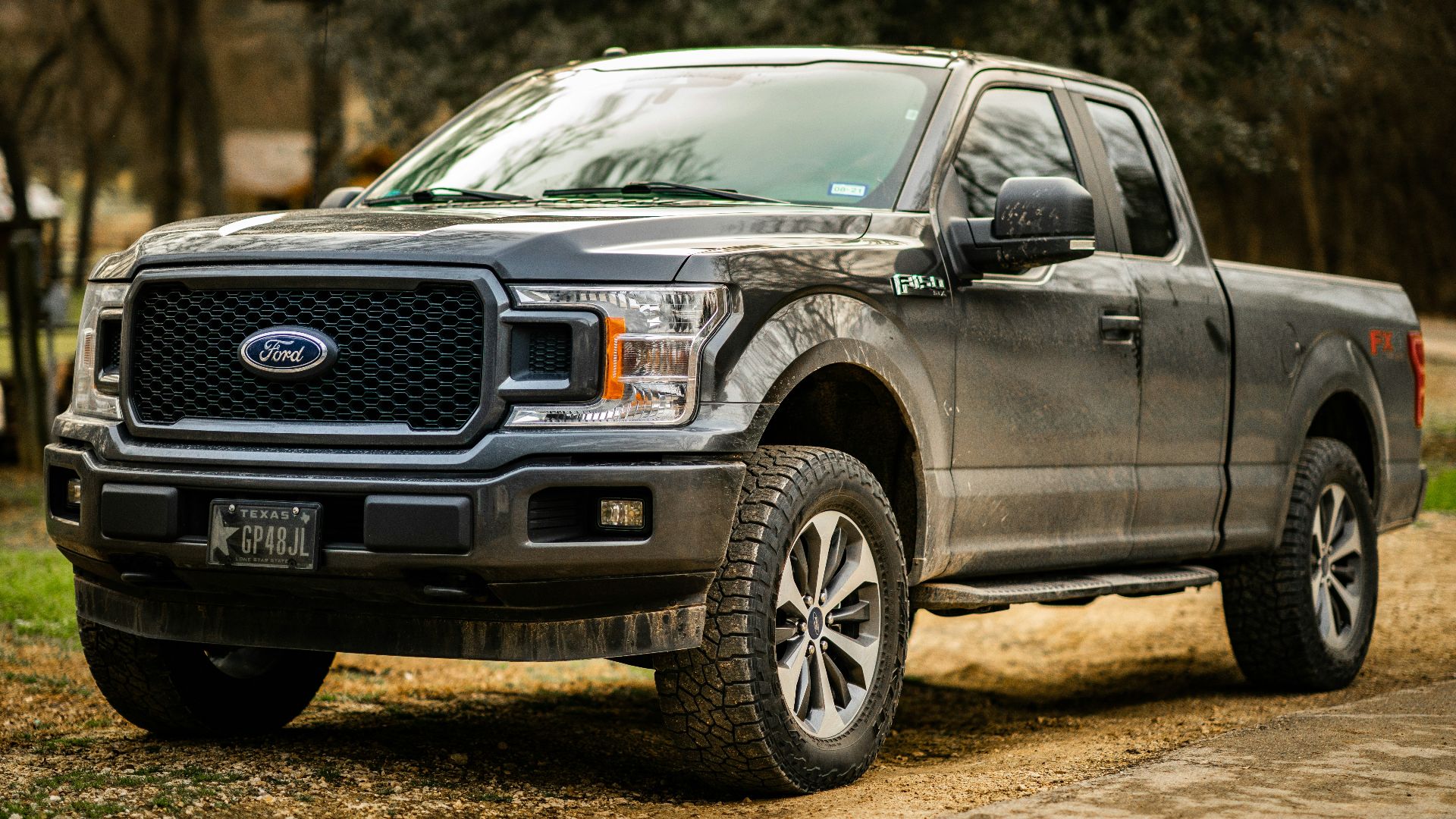 black ford suv on dirt road during daytime