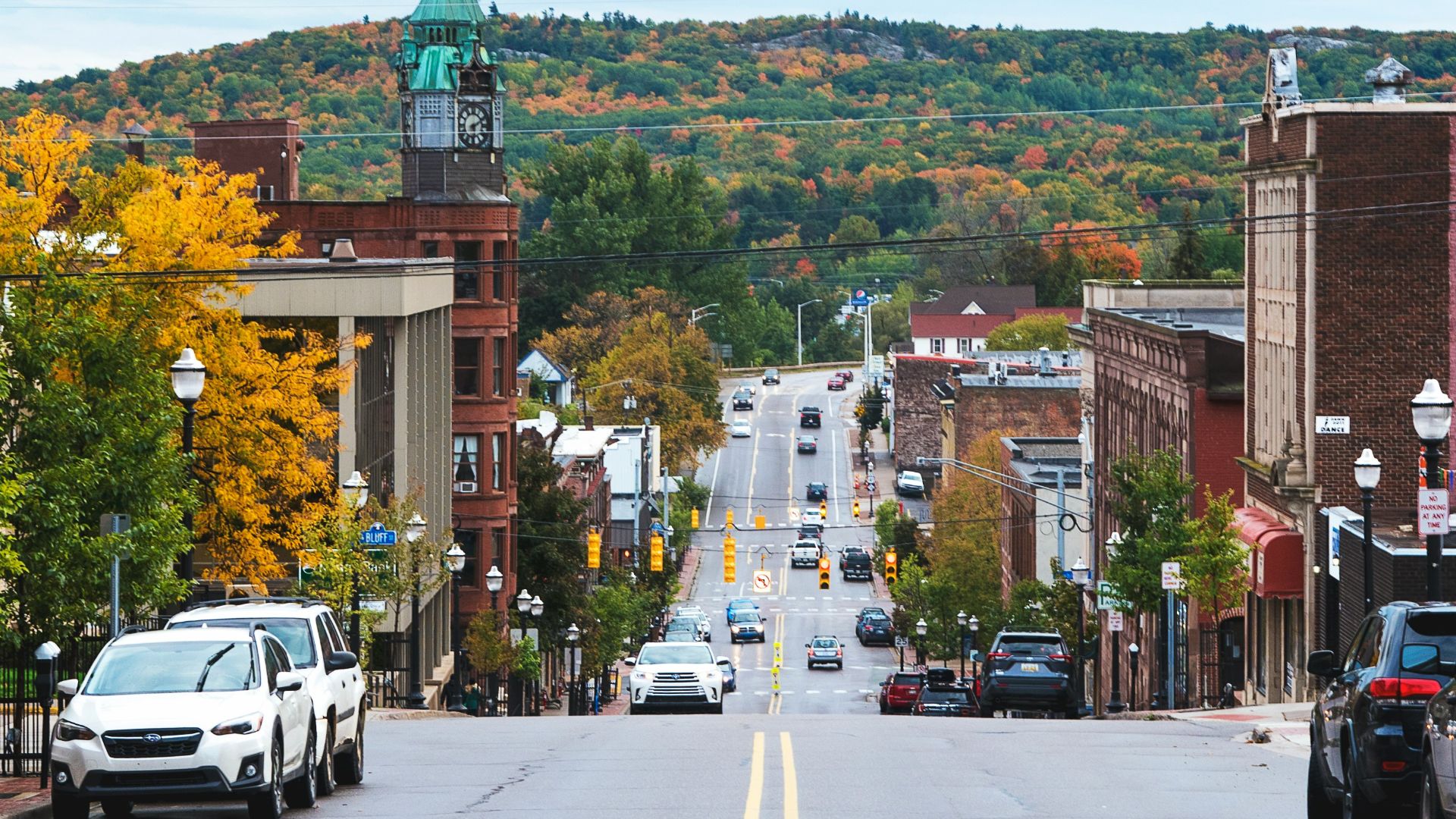 cars parked on side of the road near buildings during daytime