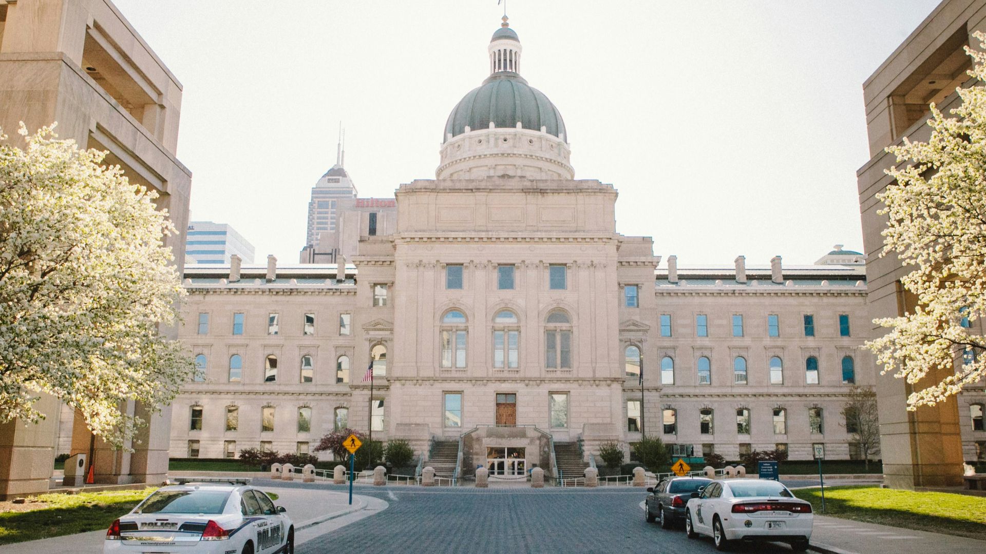 white sedan parked near white concrete building during daytime