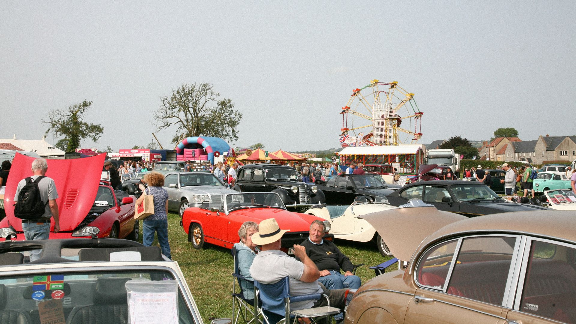 A crowd of people standing around a car show