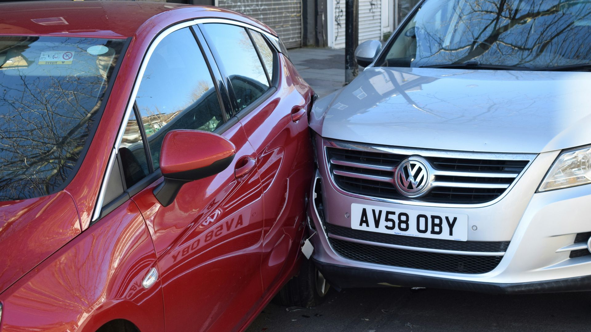 two cars parked next to each other in a parking lot