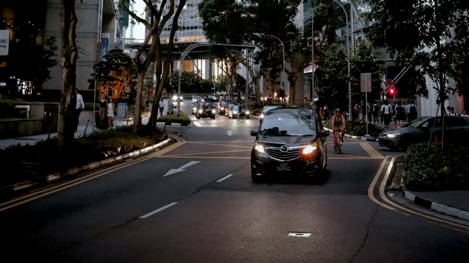A car driving down a street next to tall buildings