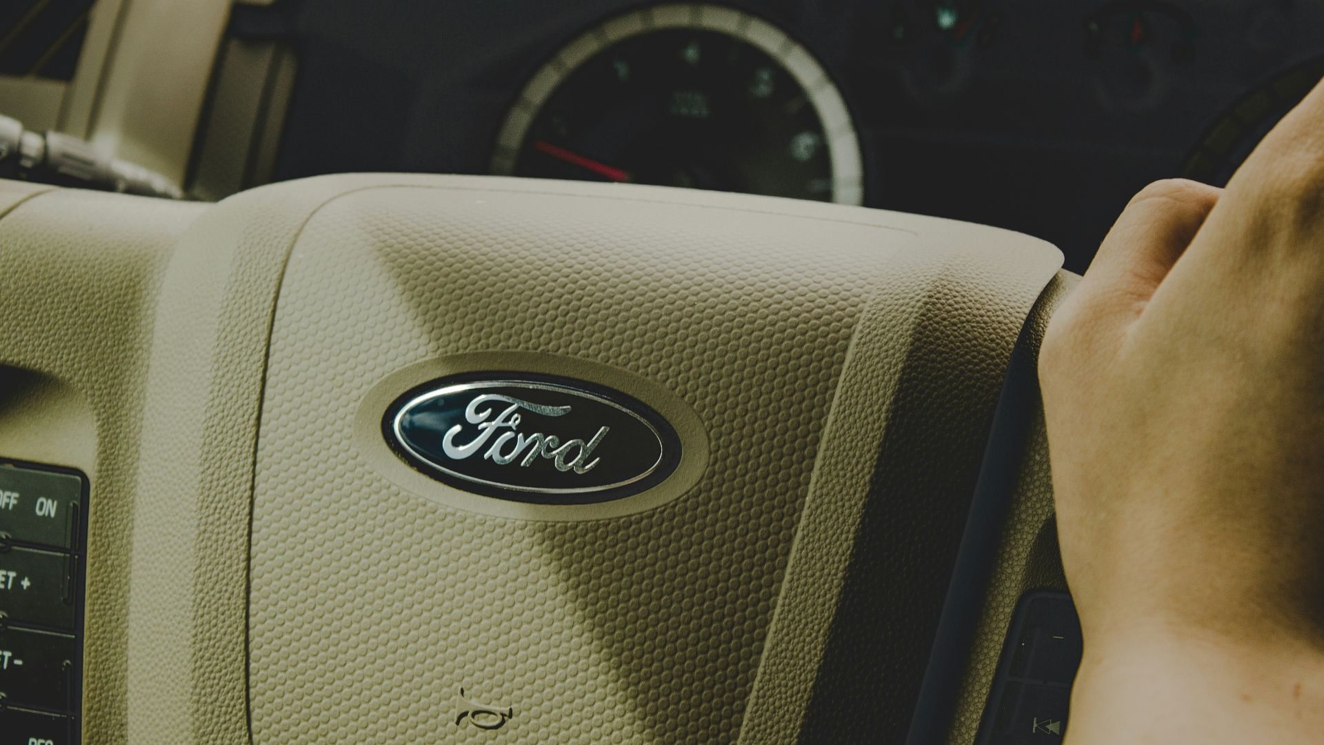 person holding Ford steering wheel