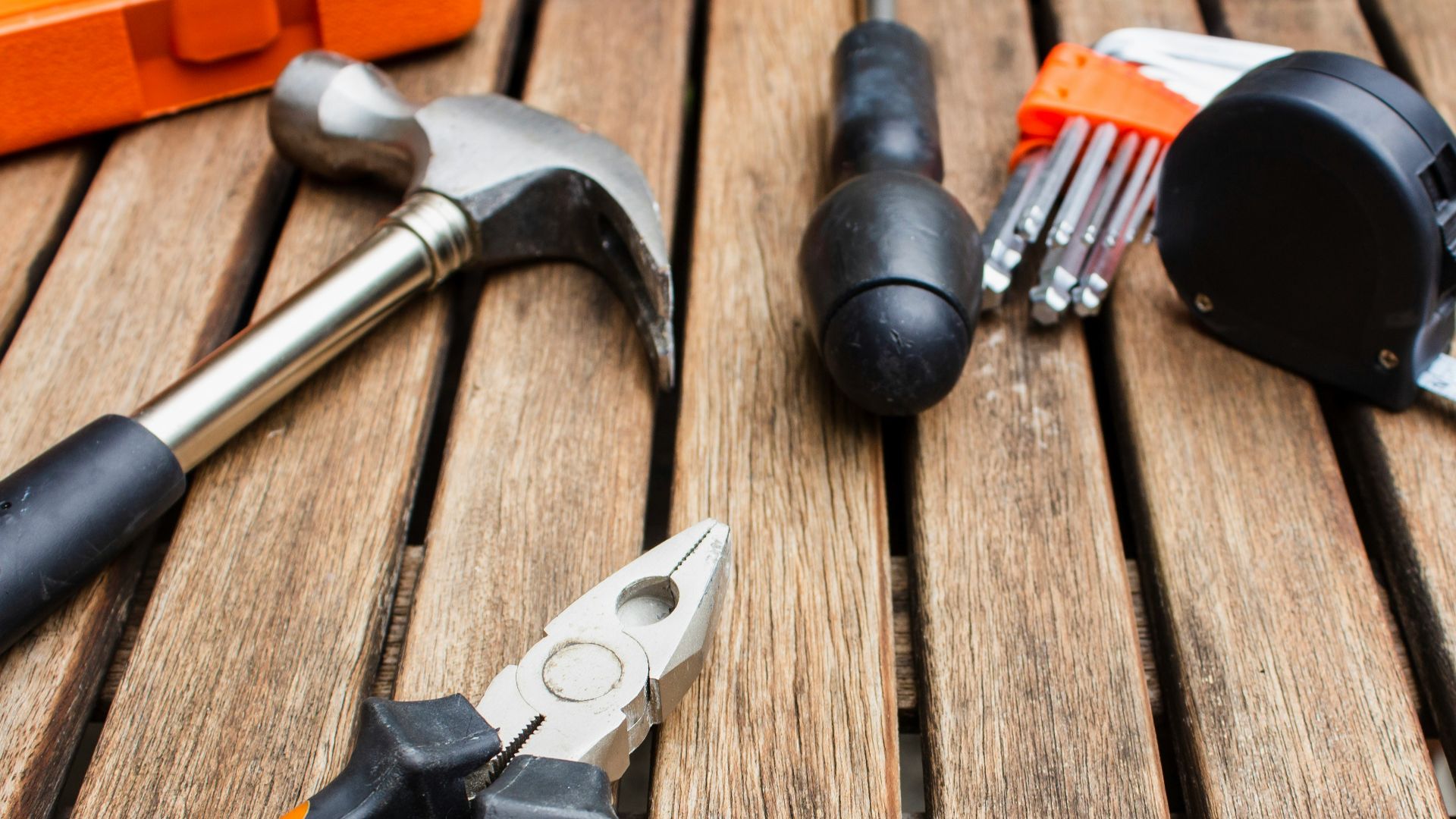 assorted-type carpentry tools on brown surface