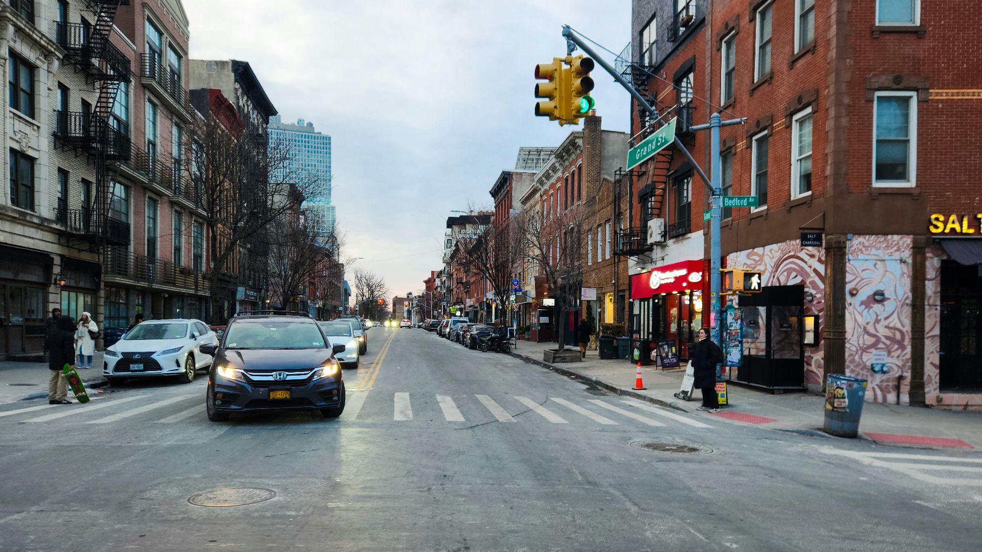 A city street filled with traffic next to tall buildings