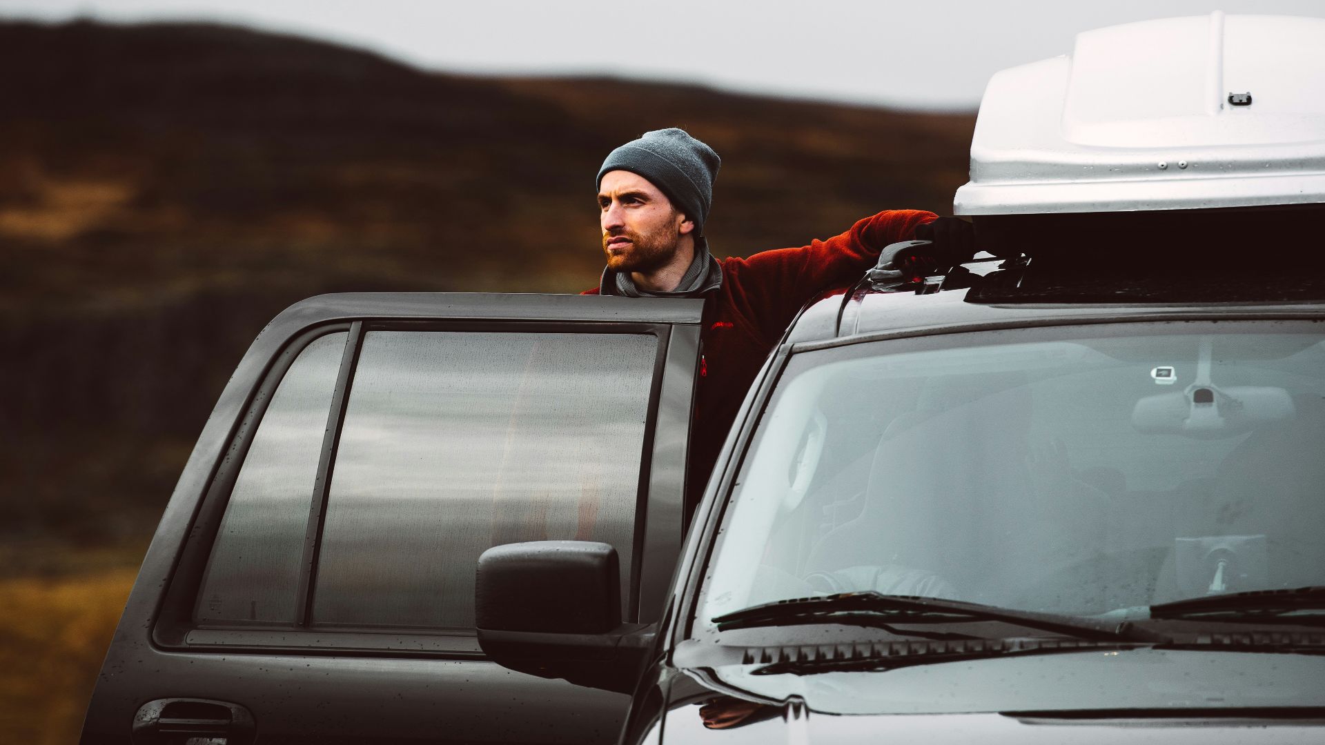 man standing beside of black SUV