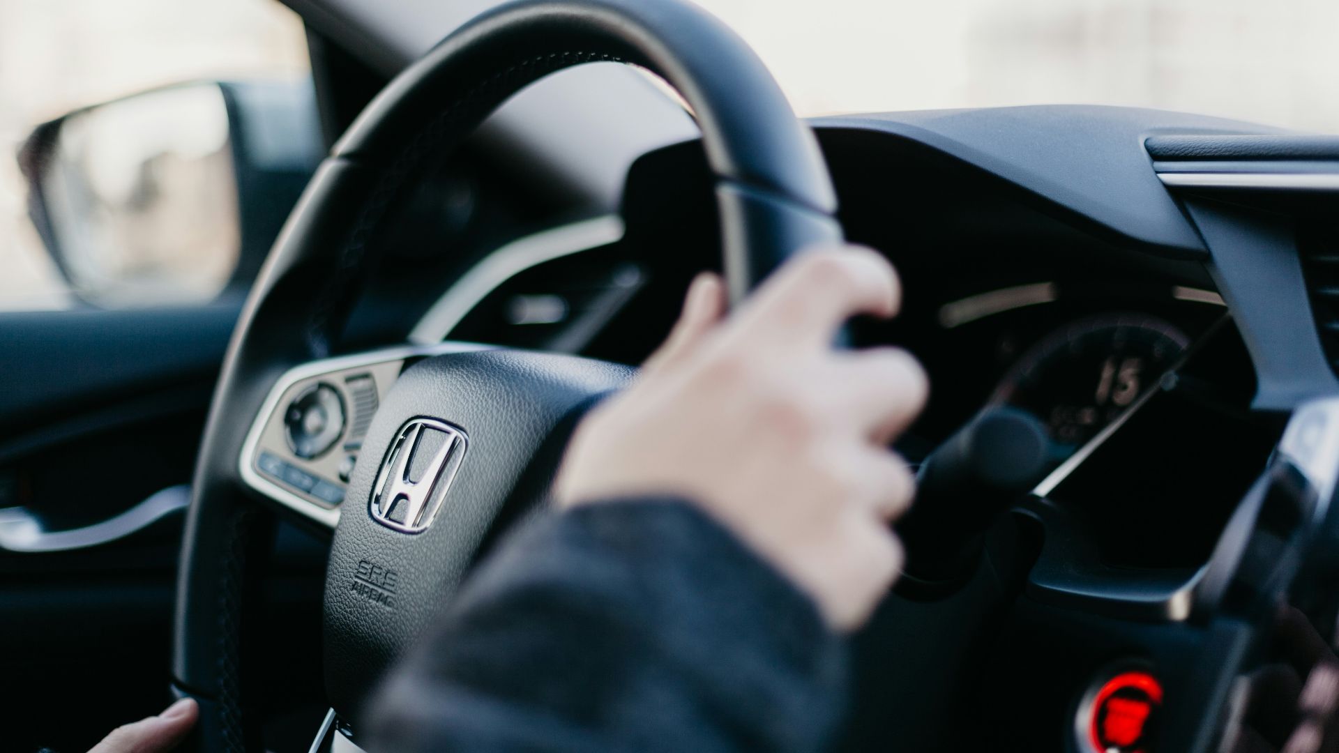 shallow focus photo of person driving Honda car