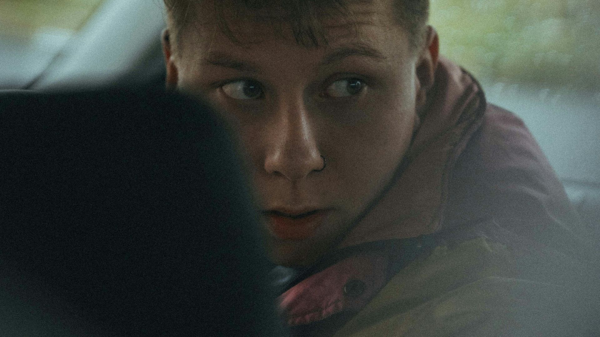 man in brown jacket sitting on car seat