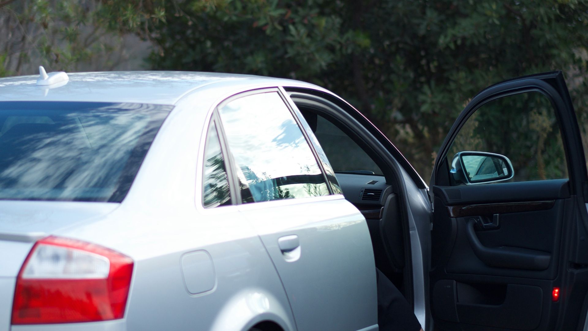 A woman exits her car.