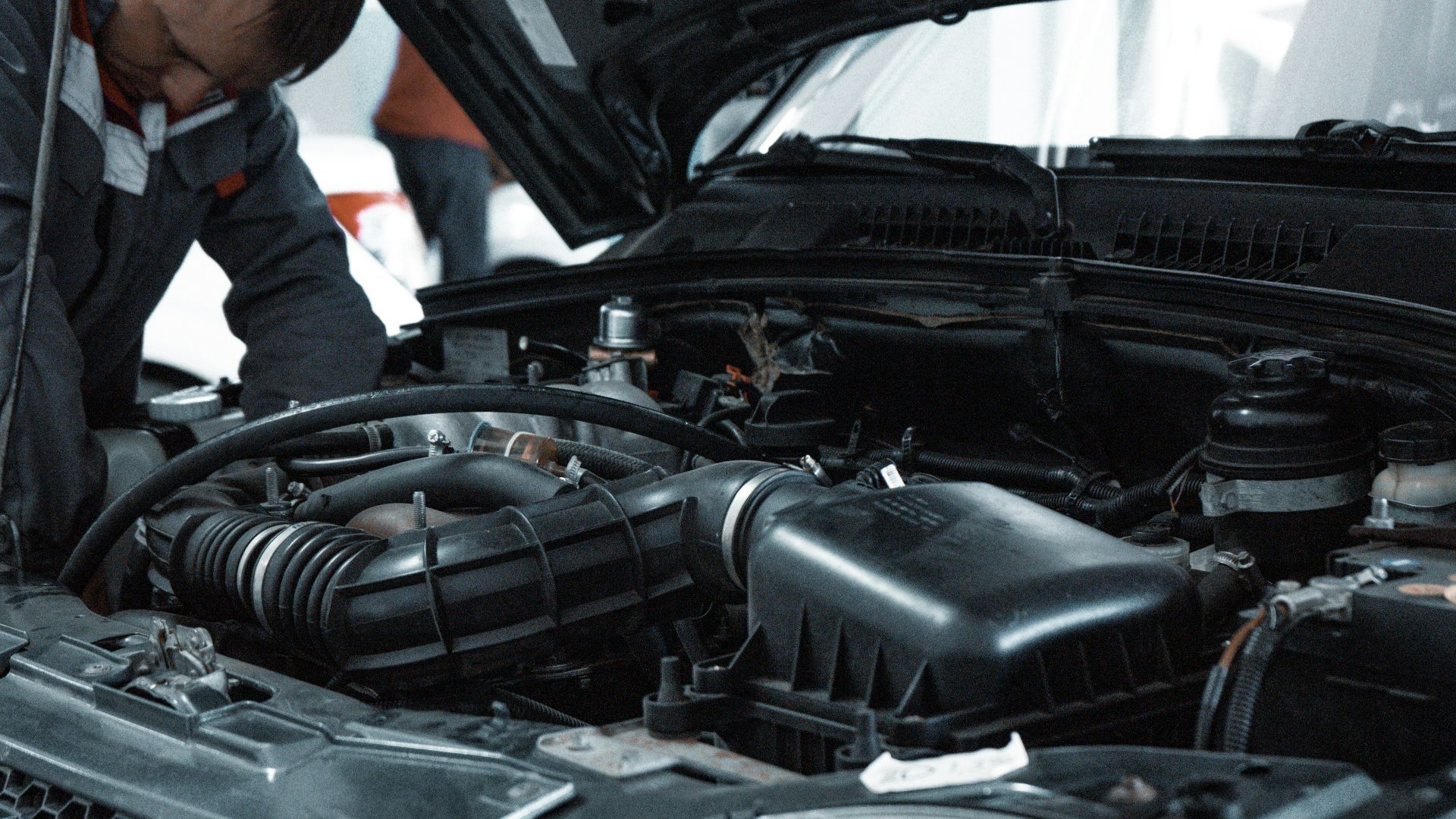 man in white shirt standing beside black car