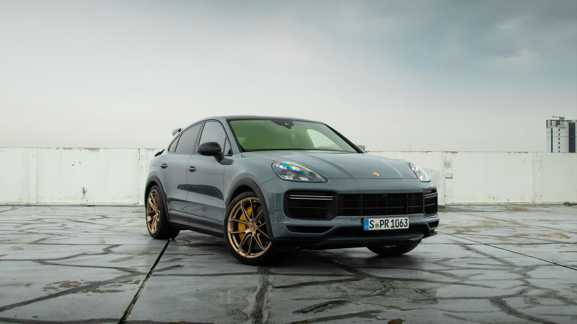 a grey porsche cayen is parked in a parking lot