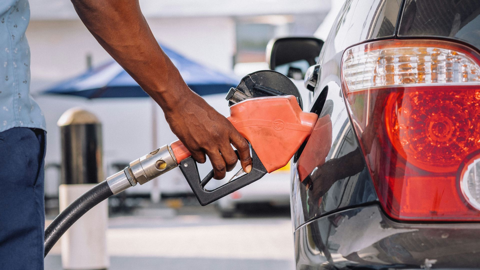 a man pumping gas into his car at a gas station